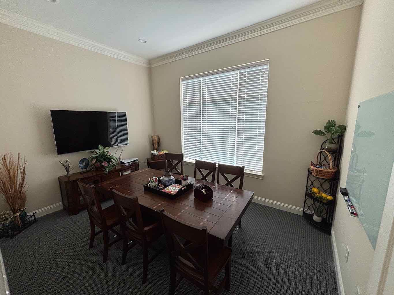 Conference and group room with large table, TV, and natural light